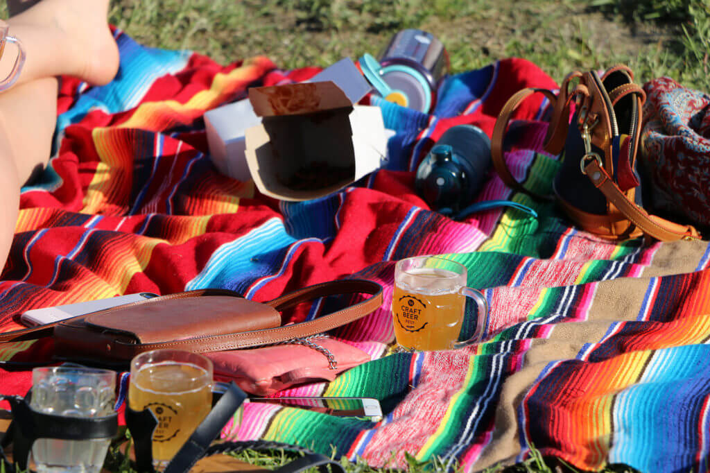 Colourful blanket with beer filled mug and personal belongings
